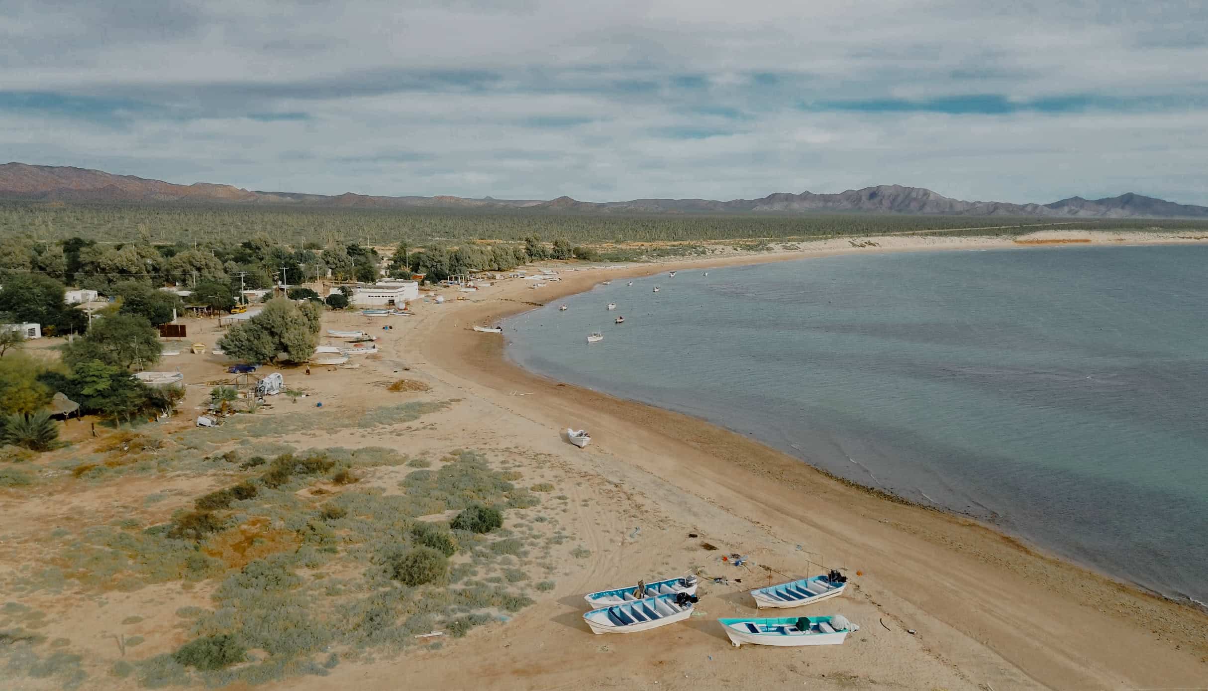 Vista aérea de Desemboque de los Seris y su bahía, con lanchas varadas en la playa
